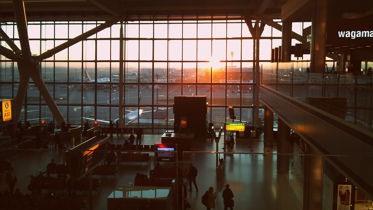 picture of heathrow airport internal waiting area with the sun setting or rising through a large window