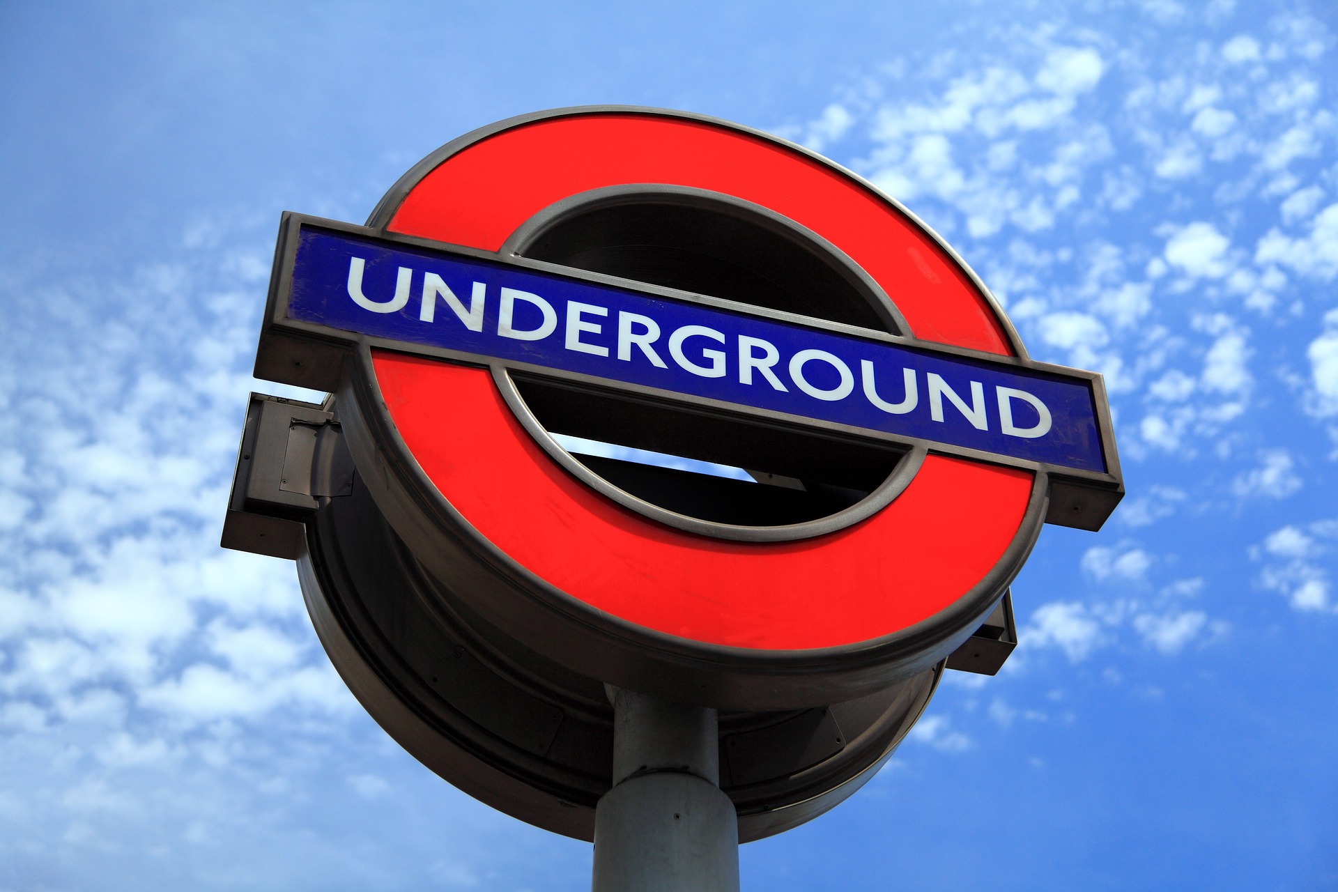 a pciture of a london underground sign, a red ring with a blue bar with 'underground' written in white